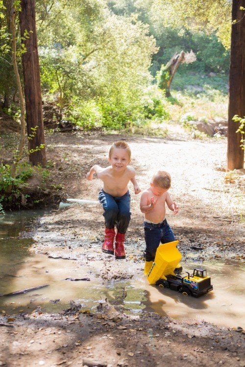 A boy jumping in a puddle